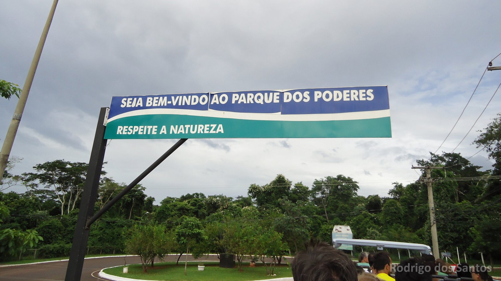 Entrada do Parque dos Poderes, em Campo Grande, com placas e arborização.